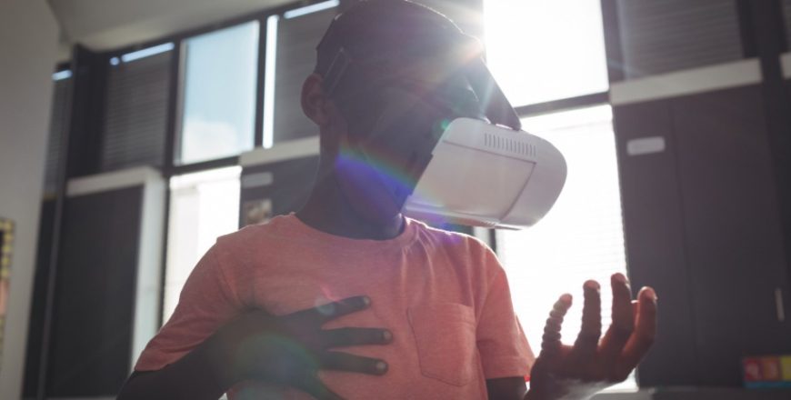Black young student using VR set in class